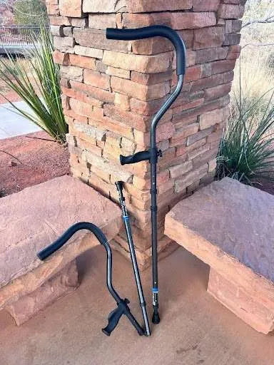 Walking canes leaning against brick wall outdoors.