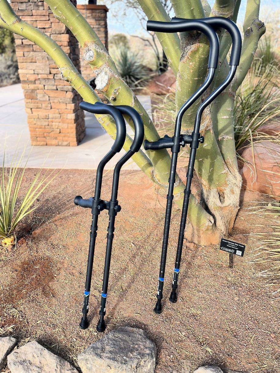 Ergonomic forearm crutches leaning against a tree.