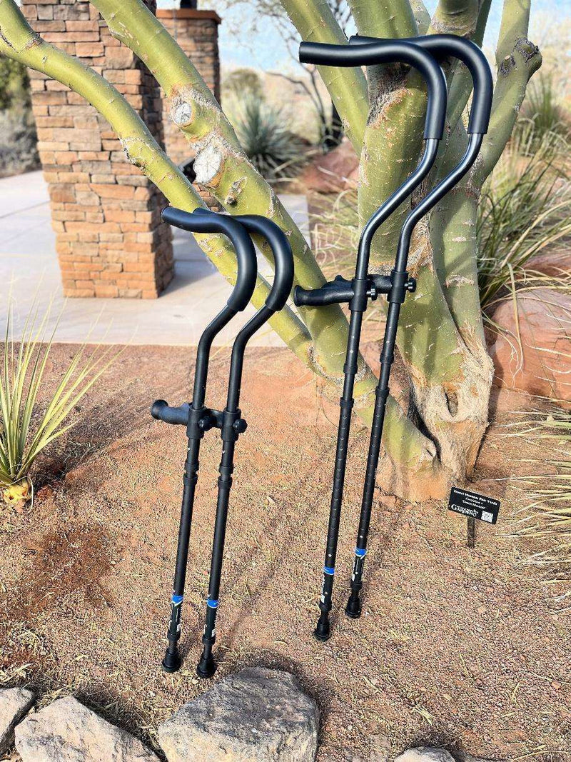 Ergonomic forearm crutches leaning against a tree.