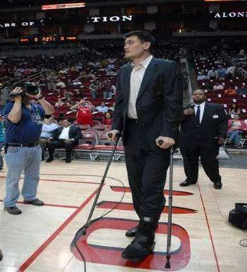 Basketball player on crutches at an indoor stadium.
