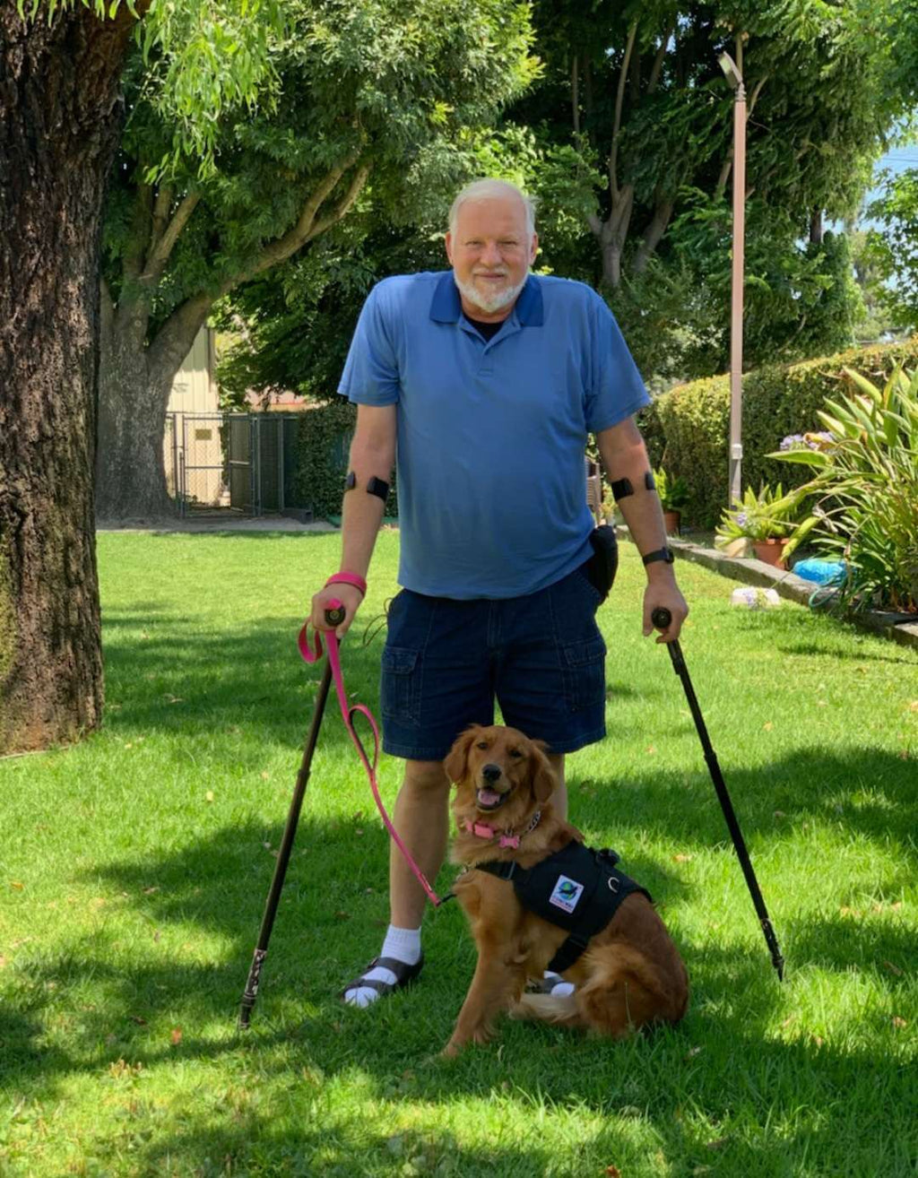 Man with in-Motion Pro forearm crutches and his service dog in a garden