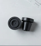 Pair of in-Motion articulating rubber crutch tips on a gray surface