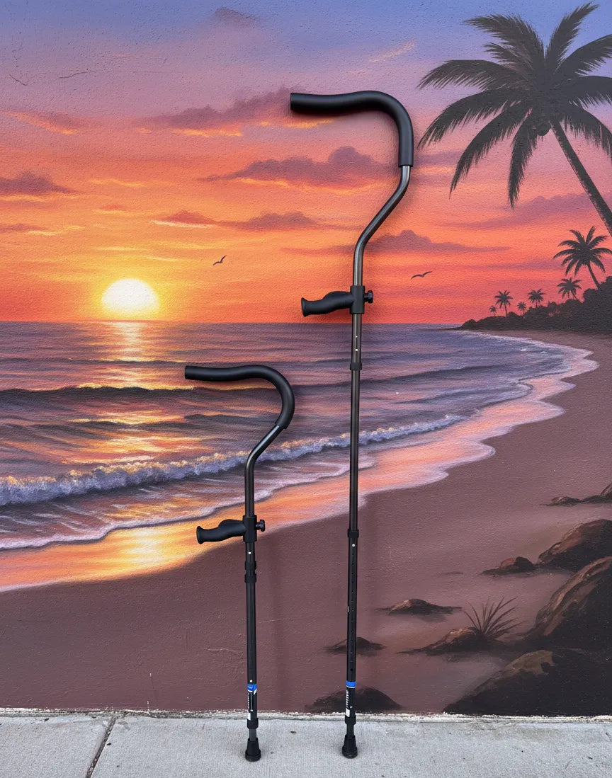 Pair of in-Motion Pro underarm crutches against a beach sunset mural
