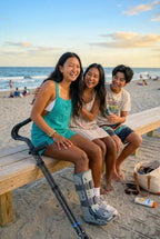 Friends at the beach at sunset with in-Motion Pro underarm crutches nearby